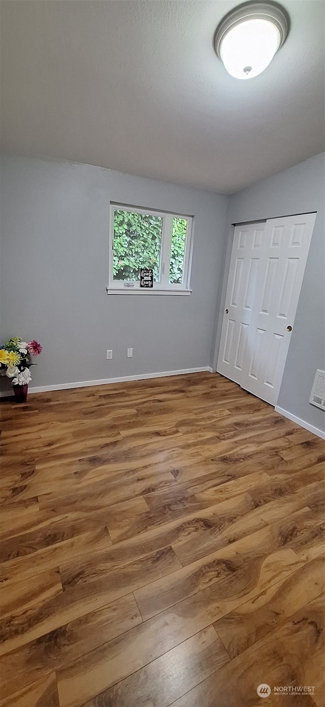 unfurnished bedroom with a closet and hardwood / wood-style floors