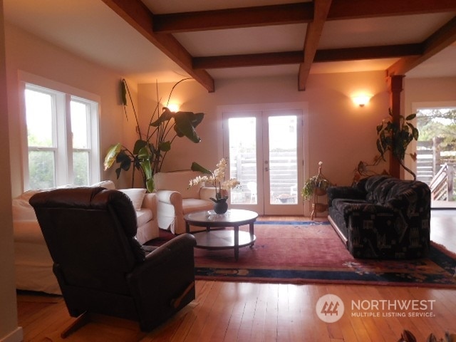 living room with hardwood / wood-style floors, plenty of natural light, coffered ceiling, and beamed ceiling