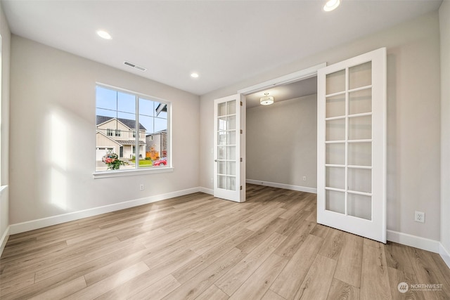 unfurnished room with light hardwood / wood-style floors and french doors