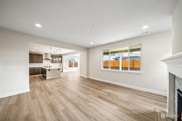 unfurnished living room with light hardwood / wood-style floors and sink