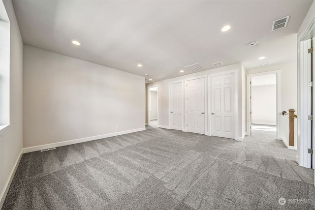 unfurnished bedroom featuring two closets and carpet flooring