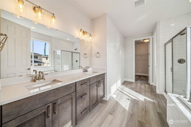 bathroom featuring vanity, hardwood / wood-style floors, and a shower with door