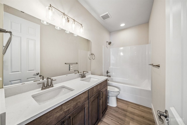 full bathroom featuring vanity, shower / washtub combination, hardwood / wood-style floors, and toilet