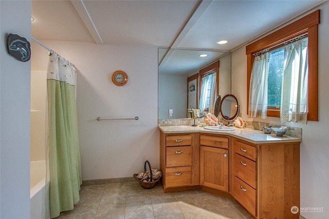 bathroom with shower / bathtub combination with curtain, vanity, and baseboards