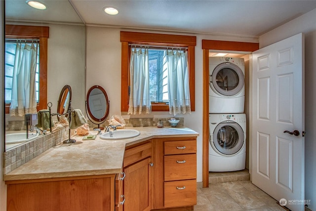 bathroom with tasteful backsplash, stacked washing maching and dryer, and vanity