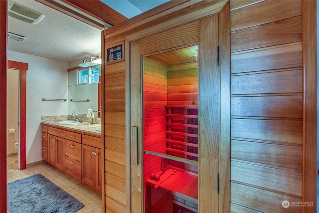 full bath featuring visible vents, toilet, a sink, tile patterned floors, and double vanity