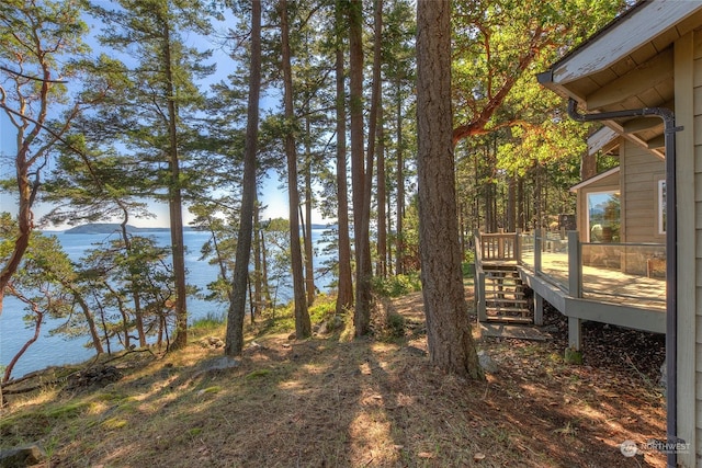 view of yard with a deck with water view