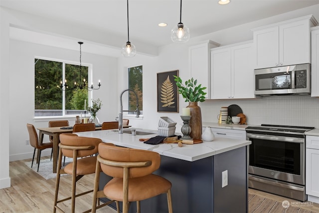 kitchen with white cabinetry, a center island with sink, and appliances with stainless steel finishes