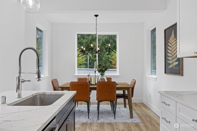 dining room featuring light hardwood / wood-style floors, sink, and a chandelier