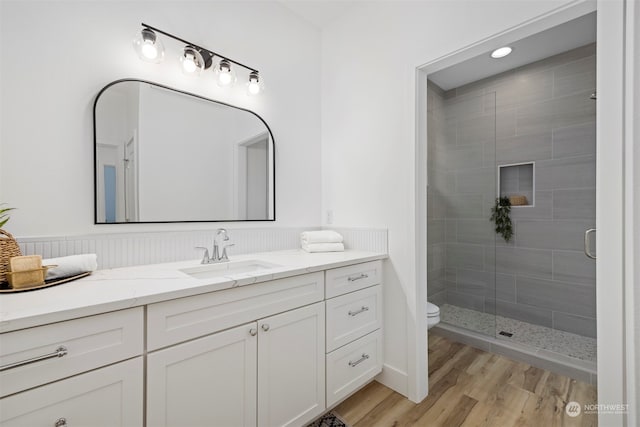 bathroom with vanity, toilet, an enclosed shower, and hardwood / wood-style flooring