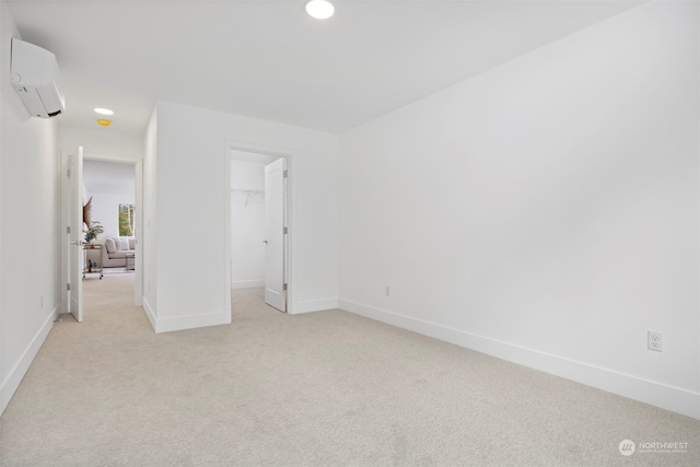 carpeted spare room featuring a wall unit AC