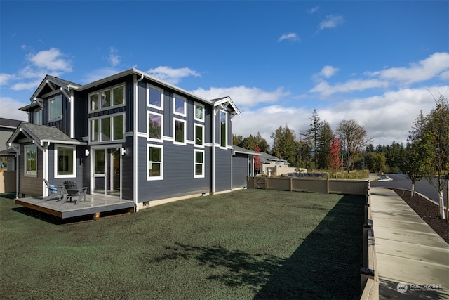 view of side of home featuring a deck and a lawn