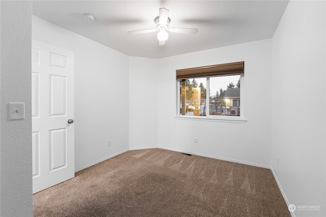 empty room featuring carpet flooring and ceiling fan