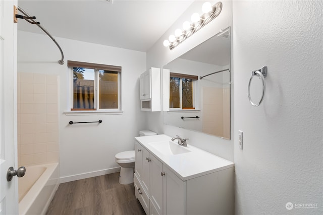 full bathroom with hardwood / wood-style floors, vanity, toilet, and shower / bath combination