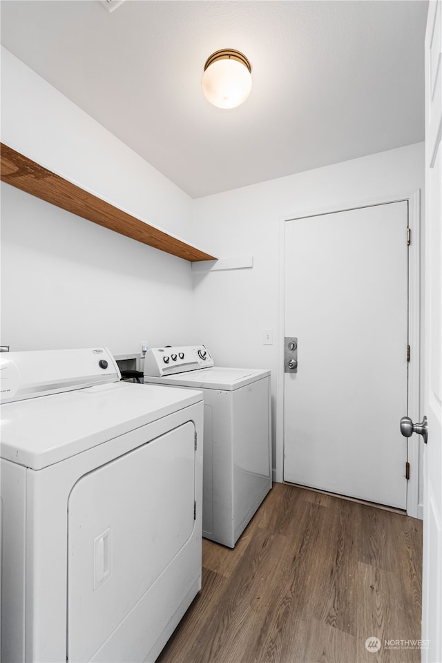 laundry room with washing machine and dryer and dark wood-type flooring