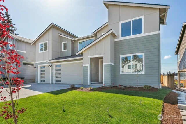 view of front of property featuring a garage and a front lawn