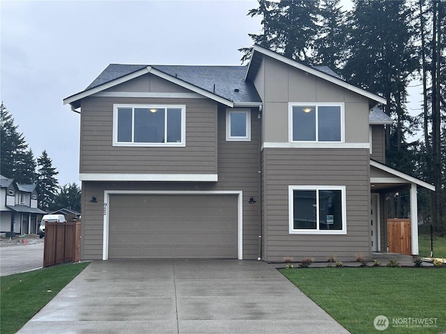 view of front of house with an attached garage, concrete driveway, a front lawn, and fence