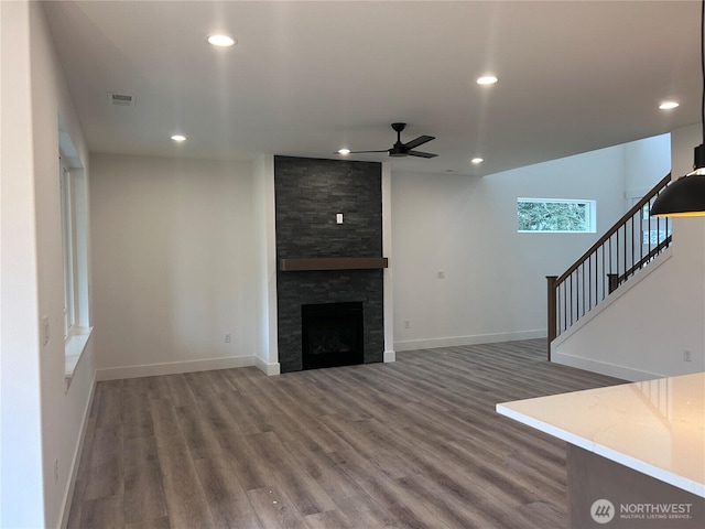 unfurnished living room with visible vents, baseboards, recessed lighting, a fireplace, and wood finished floors