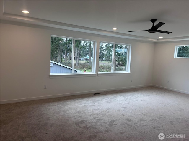 spare room featuring plenty of natural light, recessed lighting, carpet, and visible vents