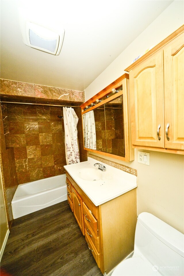 full bathroom featuring vanity, hardwood / wood-style floors, toilet, and shower / bathtub combination with curtain