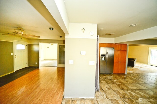 kitchen with ceiling fan, wood-type flooring, and stainless steel fridge with ice dispenser