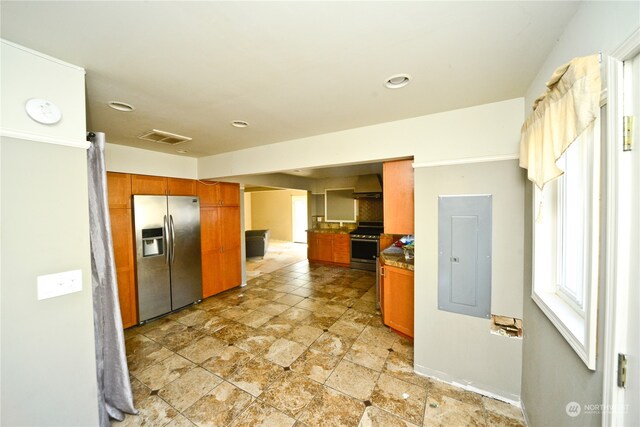 kitchen with electric panel, appliances with stainless steel finishes, and range hood