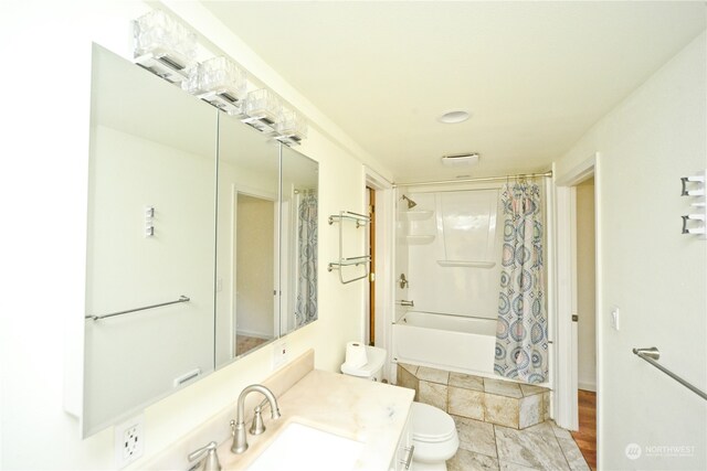 full bathroom featuring toilet, shower / bath combination with curtain, and vanity