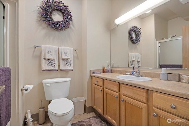 bathroom with tile patterned floors, walk in shower, vanity, and toilet