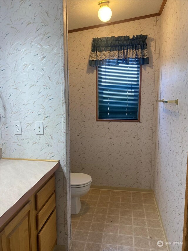 bathroom with vanity, crown molding, and toilet