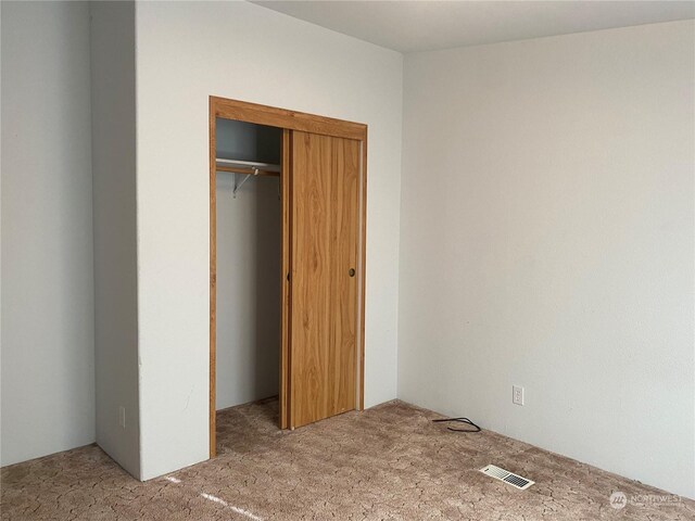 unfurnished bedroom featuring carpet floors and a closet