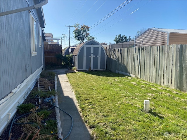 view of yard with an outbuilding, a fenced backyard, and a storage unit