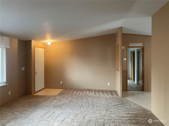 empty room featuring visible vents and vaulted ceiling