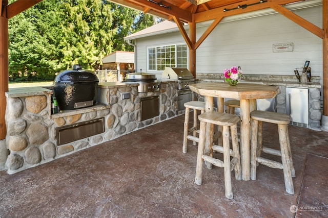 view of patio featuring an outdoor kitchen, a bar, and a grill