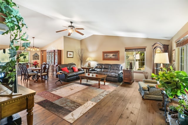 living room with lofted ceiling, ceiling fan with notable chandelier, and hardwood / wood-style floors