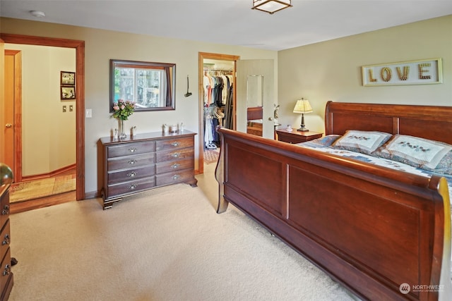 carpeted bedroom with a closet and a spacious closet