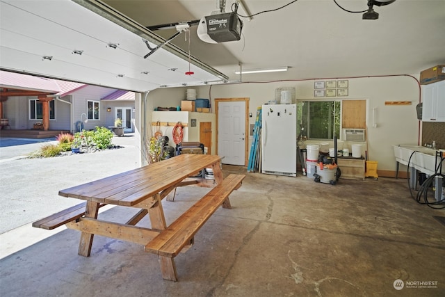 garage with a garage door opener and white fridge