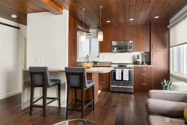 kitchen featuring a kitchen bar, stainless steel appliances, wooden ceiling, brown cabinetry, and light countertops