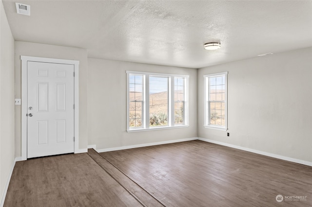 interior space with dark hardwood / wood-style flooring and a textured ceiling