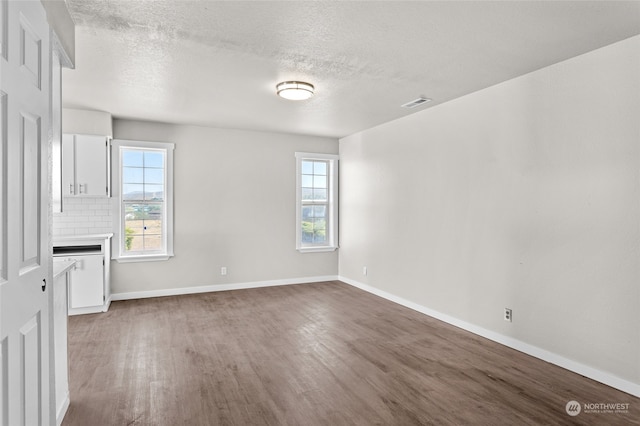 empty room with a textured ceiling and hardwood / wood-style floors