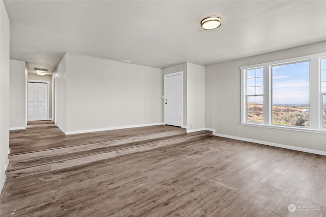 unfurnished room with a textured ceiling and hardwood / wood-style flooring