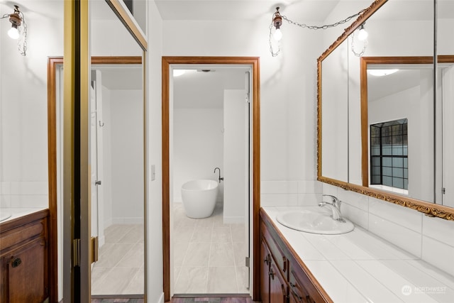 bathroom featuring vanity, tile patterned floors, and a washtub