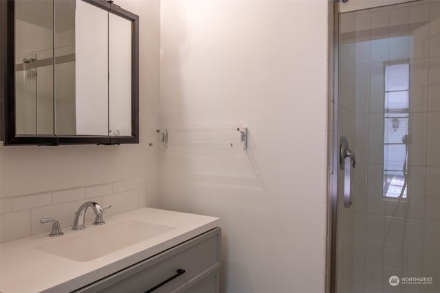 bathroom featuring vanity, walk in shower, and backsplash