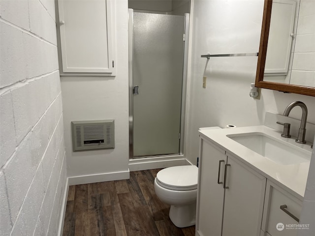 bathroom with hardwood / wood-style floors, toilet, a shower with door, and vanity