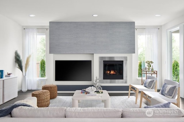 living room featuring a fireplace, baseboards, wood finished floors, and recessed lighting