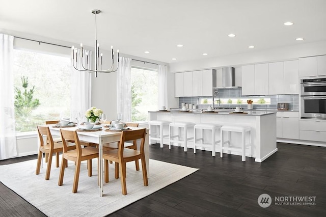 dining space featuring dark wood finished floors, a notable chandelier, and recessed lighting