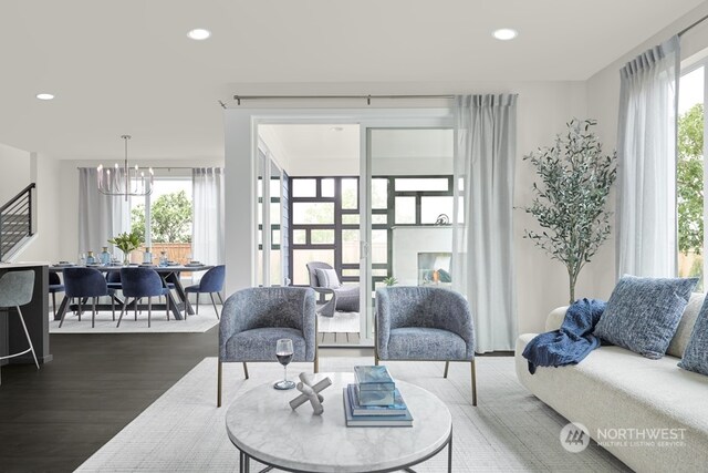 living room with plenty of natural light, hardwood / wood-style floors, and a chandelier