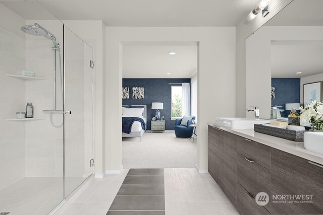 bathroom with tile patterned flooring, vanity, and walk in shower