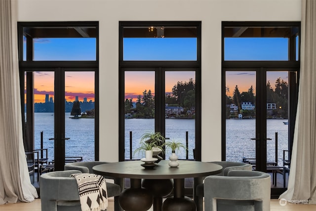 dining room featuring french doors and a water view