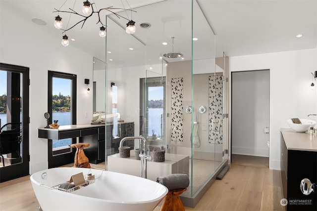 bathroom featuring hardwood / wood-style floors, independent shower and bath, and vanity