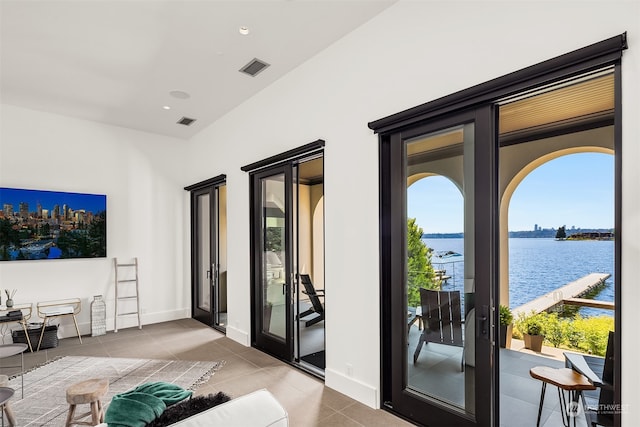 entryway featuring a water view and tile patterned floors